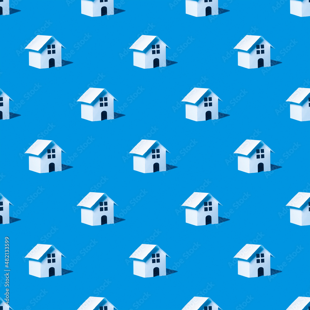 Seamless pattern with toy houses on a blue background.