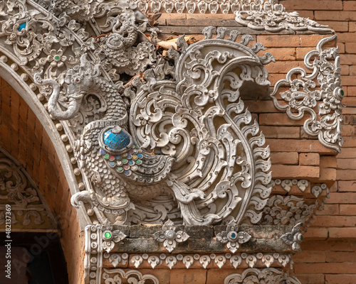 Traditional intricate bas-relief stucco decor of a hatsadiling, a mythological half bird half elephant animal at historic Lanna style Wat Lok Moli or Lok Molee buddhist temple, Chiang Mai, Thailand photo