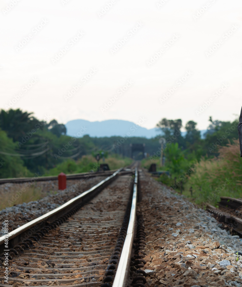 Fototapeta premium single track linear rail The background is dark blue sky and mountains. transport and industry images