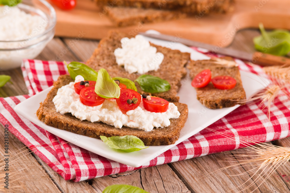 Rye bread with cottage cheese, basil and tomato.

