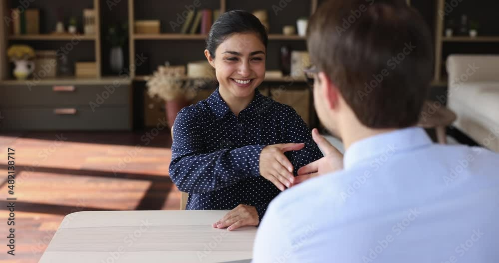 Attractive Indian 25s woman pass job interview sit in front of HR manager answers questions shake hands finish successfully formal meeting at company office. Human resource, recruitment agency concept