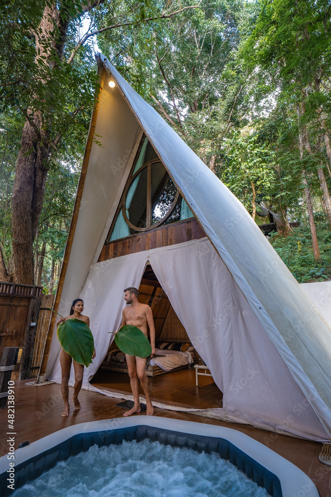 Naked couple men and women in front of their tent , glamping in nature