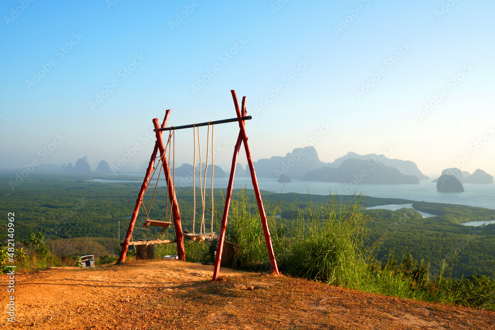 Wooden Swing on Samet Nangshe Viewpoint is the fantastic limestone formations on the bay with green mangrove forest panoramic viewpoint in Phang Nga Bay in sunny day locate at Phang Nga Thailand Wooden Swing on Samet Nangshe Viewpoint is the fantastic limestone formations on the bay with green mangrove forest panoramic viewpoint in Phang Nga Bay in sunny day locate at Phang Nga Thailand