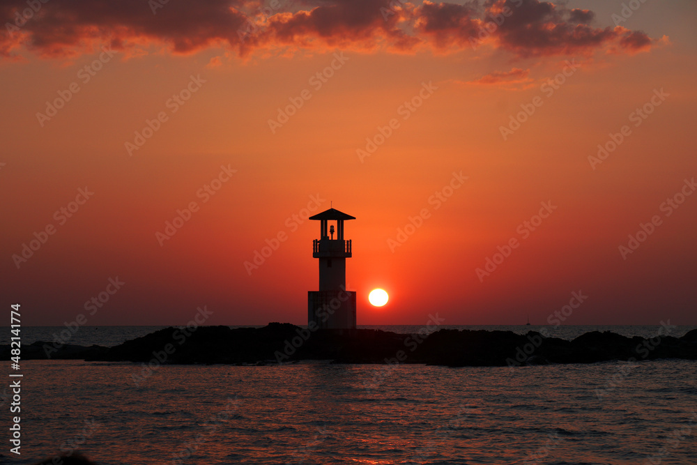Landscape nature sunset and red  twilight sky with Silhouette  lighthouse on the rock at Nang Thong Beach at Khao Lak Phang Nga Thailand - Seascape chill vibe on the beach - beautiful sky  