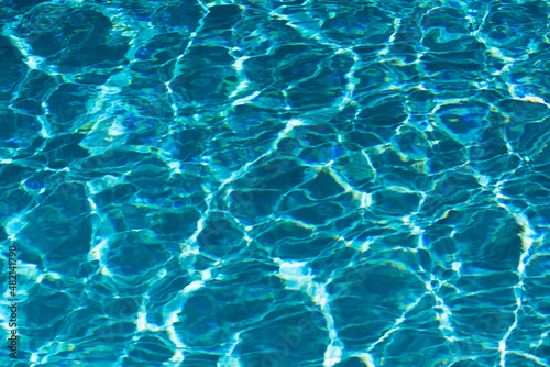 Ripple Water in swimming pool with sun reflection. Wavy water background.