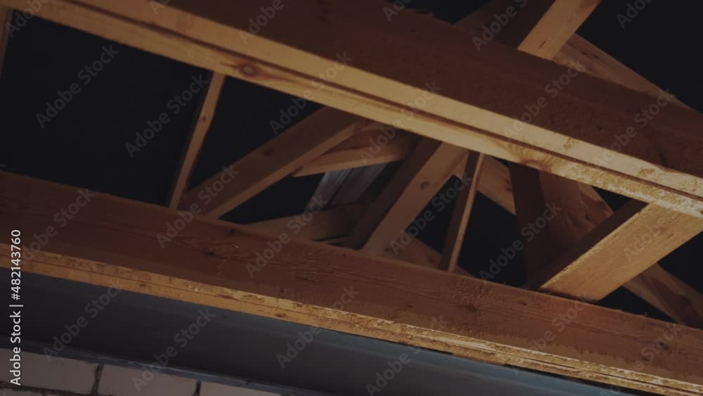 Wooden beams inside the roof of a private two-storey house without finishing, the roof of a cottage without finishing Wooden beams inside the roof of a private two-storey house without finishing, the roof of a cottage without finishing