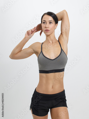young muscular sportswoman posing isolated on white background looking away © Sergey Chumakov