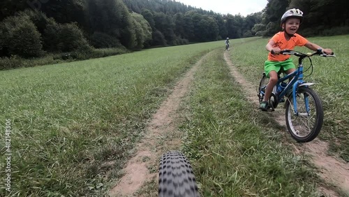 Cute little boy riding a bike.	 

Boy riding a bike along the cycle path. Stabilized video.