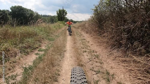 Cute little boy riding a bike.	 

Boy riding a bike along the cycle path. Stabilized video.