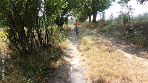 Cute little boy riding a bike.	 

Boy riding a bike along the cycle path. Stabilized video.