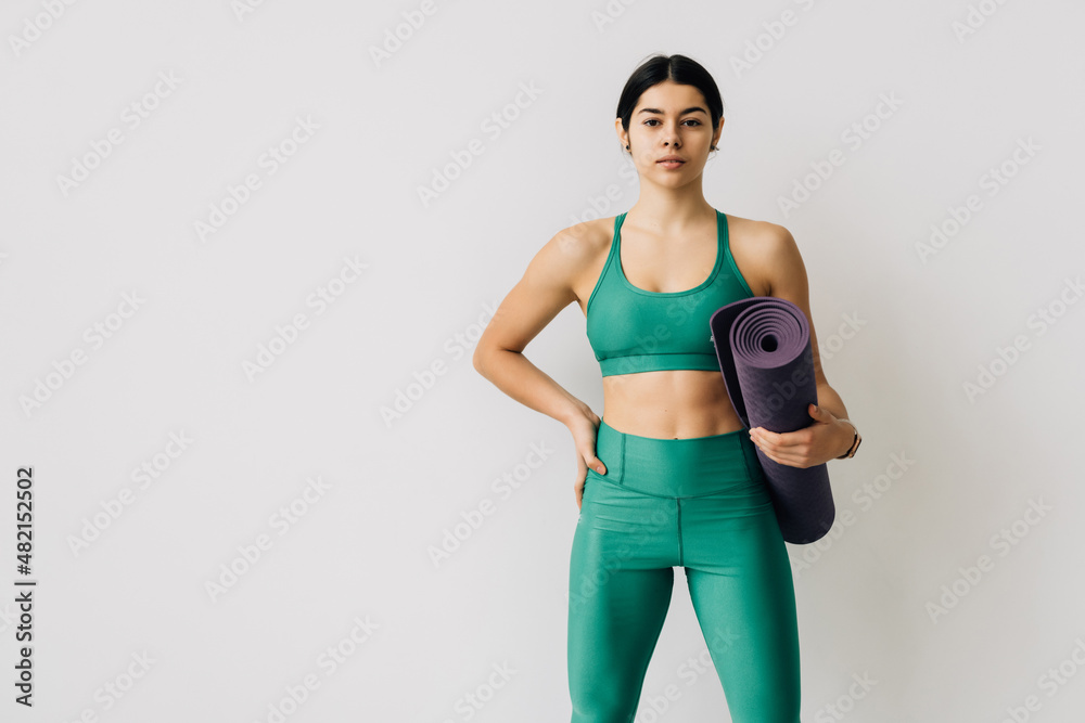 Fit woman with a gym mat isolated over white background Fit woman with a gym mat isolated over white background