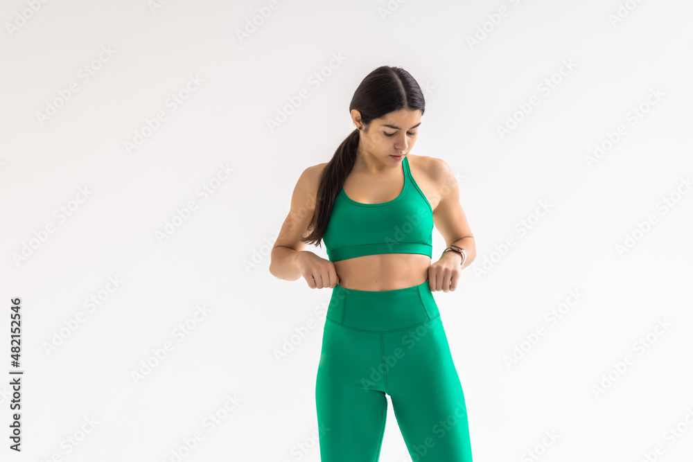 Fitness Woman lost weight and her trousers are too big on white background Fitness Woman lost weight and her trousers are too big on white background