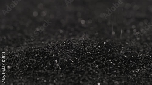 pouring black coconut charcoal close-up slo-mo, activated carbon small fraction