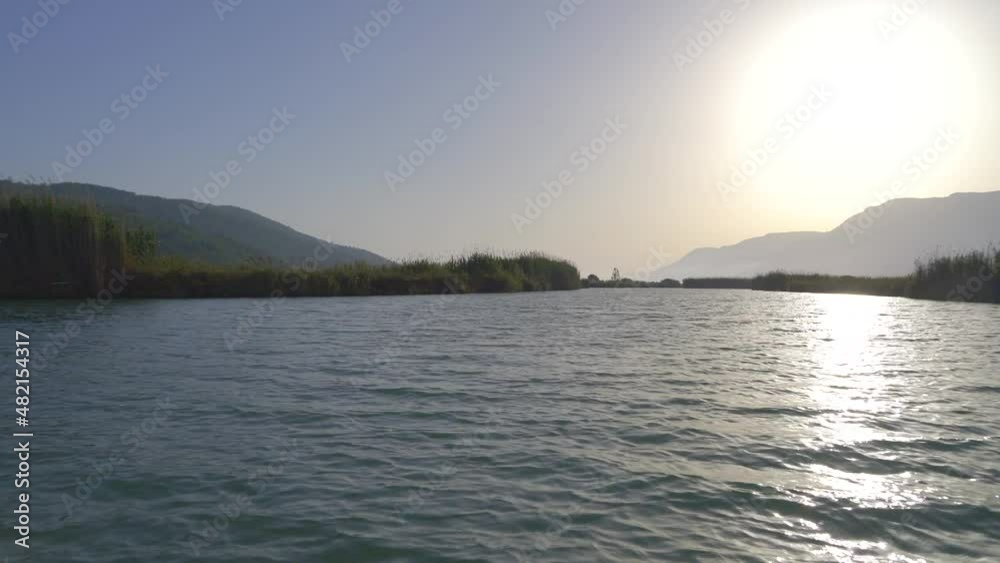 4K.A river surrounded by reeds on a flat plain.Camera going on water surface.Freshwater stream in lowland.Sunny day in summer.Peaceful, uninhabited and untouched wetland.Morass sedge rush bed reed-bed 4K.A river surrounded by reeds on a flat plain.Camera going on water surface.Freshwater stream in lowland.Sunny day in summer.Peaceful, uninhabited and untouched wetland.Morass sedge rush bed reed-bed