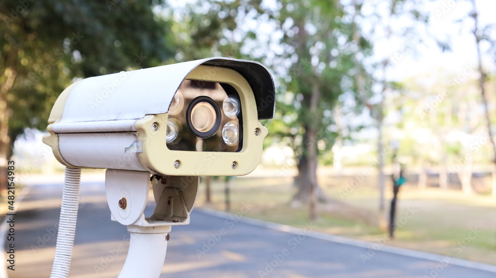Close-up of CCTV cameras. Roadside CCTV for guard house and property on street background and blurry trees with copy space. Selective