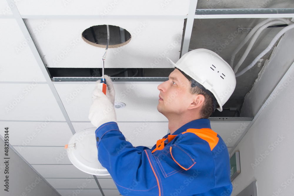 the foreman, for troubleshooting the lighting of false ceilings, checks the contacts of the lamp junction box the foreman, for troubleshooting the lighting of false ceilings, checks the contacts of the lamp junction box