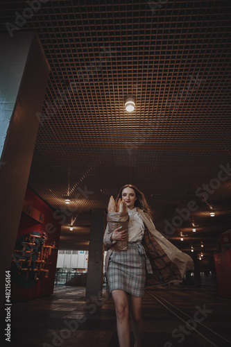 girl walks around the city French baguette in her hands