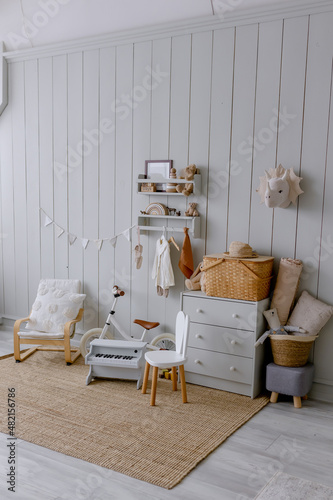 Children's room for a small child in Scandinavian eco style Wooden wall and natural jute carpet White bicycle and piano