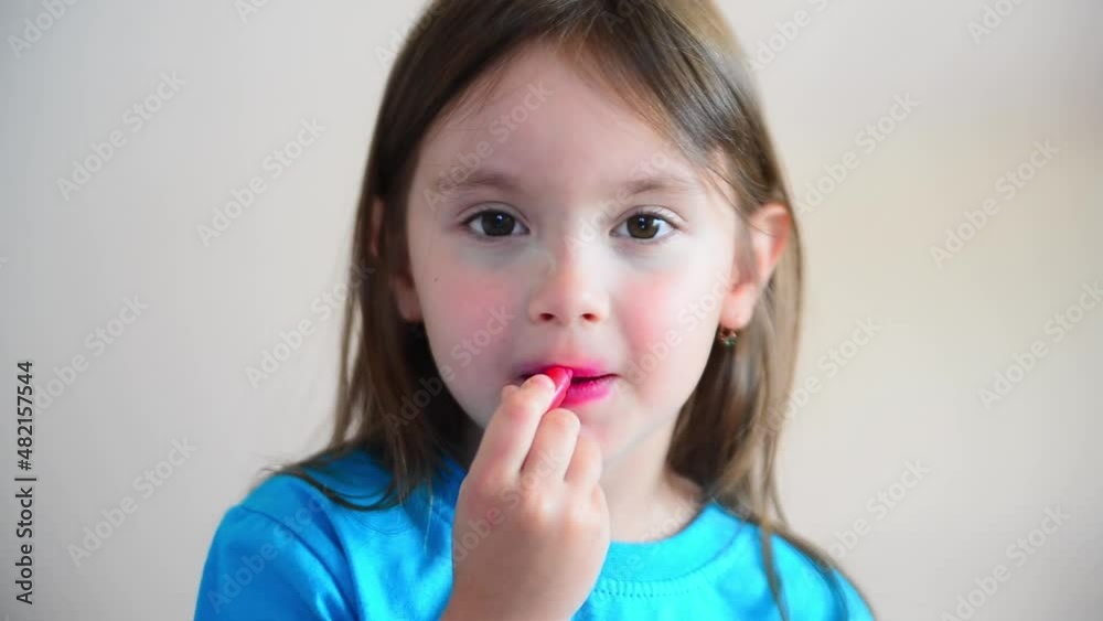 Little girl paints her Lips with makeup. Little girl 4-5 years old puts makeup on her face Little girl paints her Lips with makeup. Little girl 4-5 years old puts makeup on her face