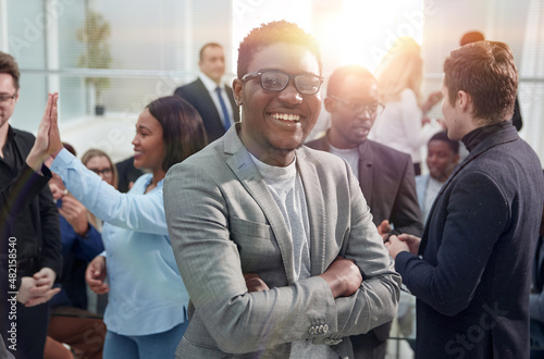 smiling young business man standing among his colleagues.