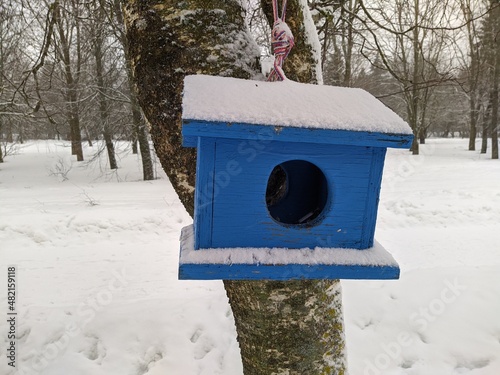 birdhouse hanging on a tree in the park in the winter season covered with snow. © Левон Мартиросян