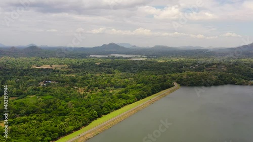 Highway along the lake surrounded by jungle and rainforest. Loggal Oya Reservoir. Sri Lanka. photo