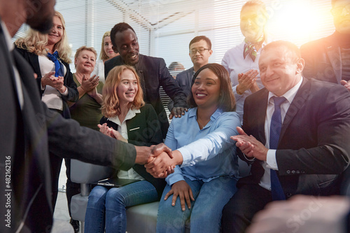 employees shaking hands at a corporate meeting.