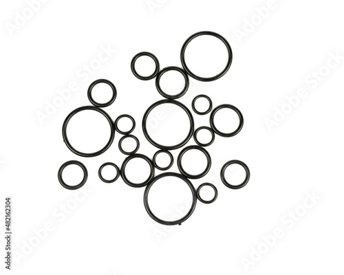 Background of o-rings and gaskets in black on a white background. Hydraulic and pneumatic o-rings in black in different sizes on a white background. Various seals for plumbing.