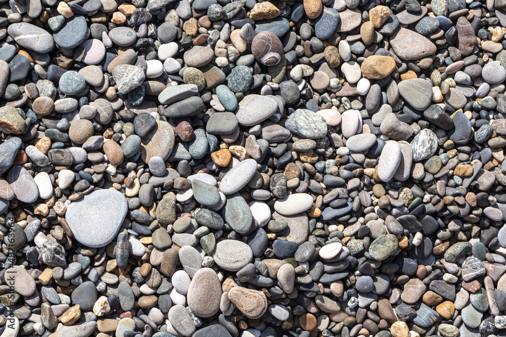 Beautiful texture of colorful smooth stones is on the beach by sea Beautiful texture of colorful smooth stones is on the beach by sea