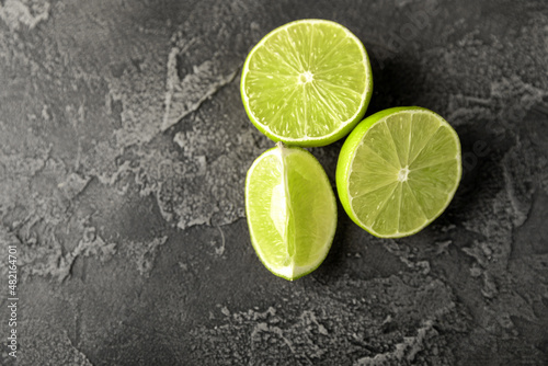 Lime, juicy ripe citrus fruits on a dark background. Ingredients for preparing refreshing drinks and cocktails. Mojito. Selective focus, top view and copy space