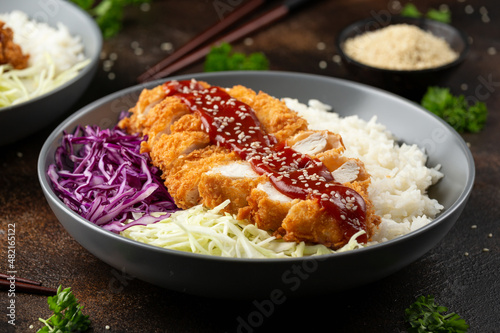 Crispy Katsu chicken with sauce, rice and cabbage. photo