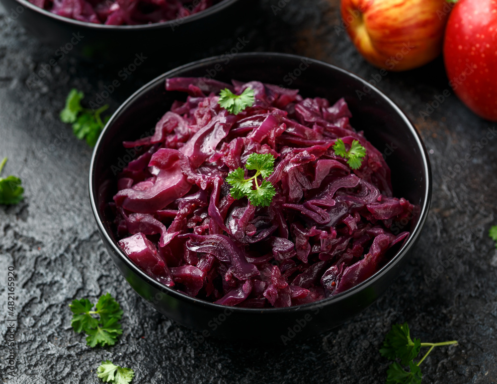 Braised Red Cabbage with apples and redcurrant in black bowl Braised Red Cabbage with apples and redcurrant in black bowl