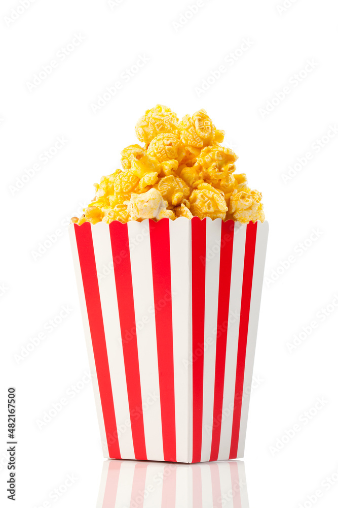caramel popcorn in a striped paper cup isolated on white background. caramel popcorn in a striped paper cup isolated on white background.