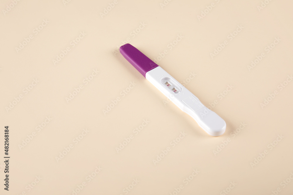 Pregnancy test kit with positive results isolated on paper background Pregnancy test kit with positive results isolated on paper background