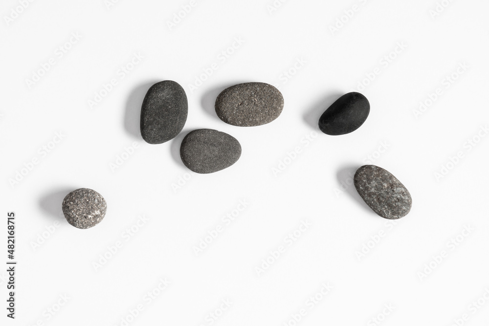 Scattered sea pebble. Smooth gray stones isolated on white background. Flat lay, top view, copy space Scattered sea pebble. Smooth gray stones isolated on white background. Flat lay, top view, copy space