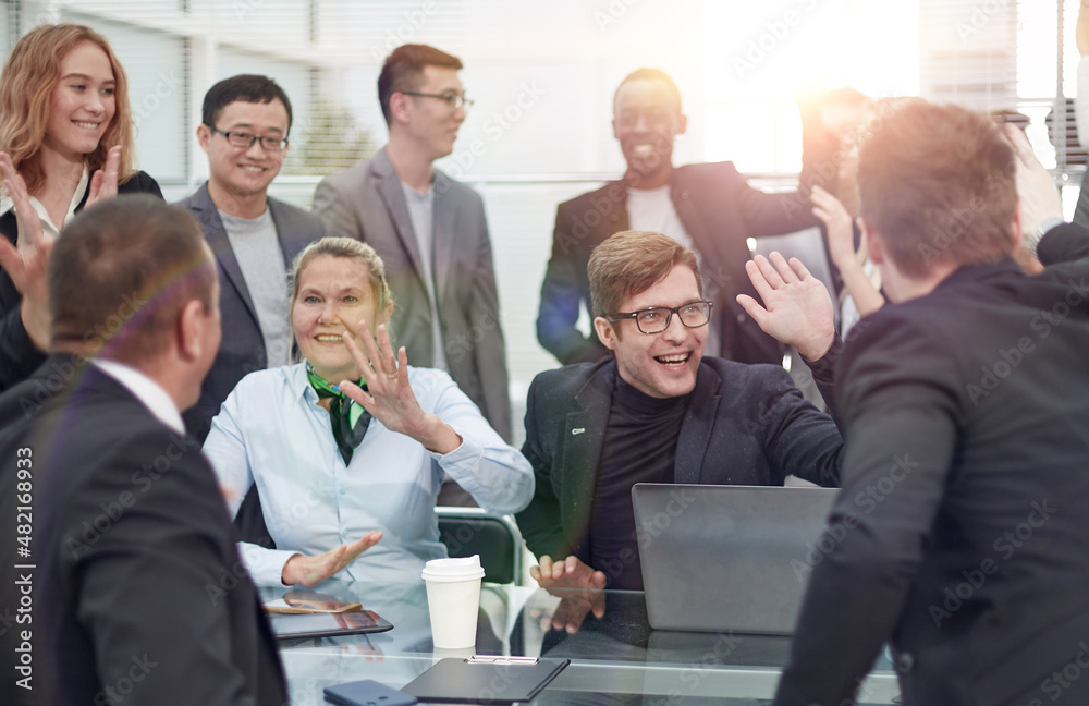 Cheerful creative business team sitting around table at office Cheerful creative business team sitting around table at office
