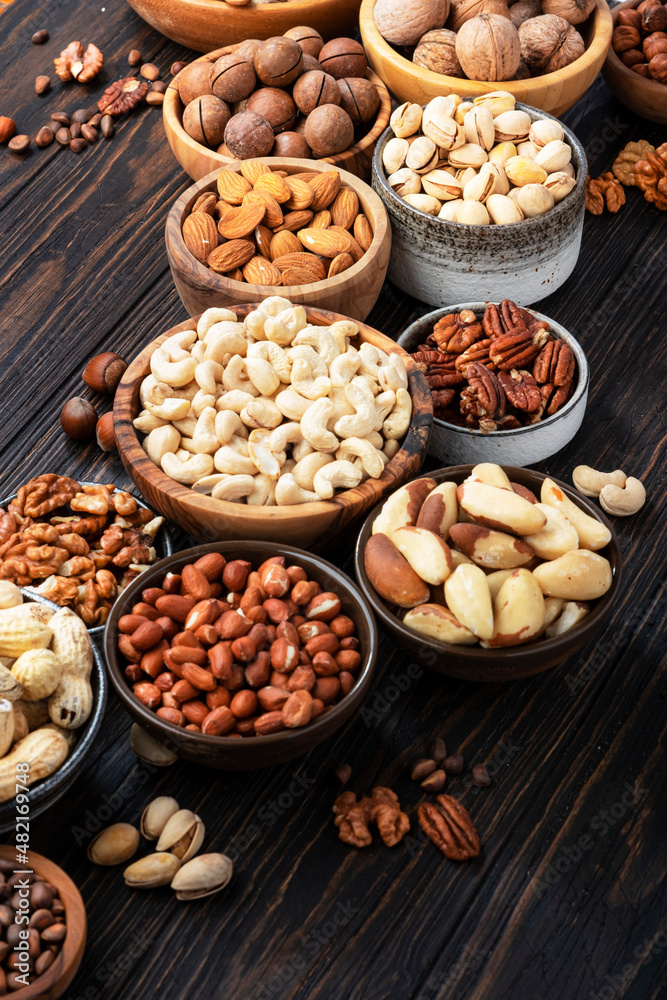 Nuts in assortment, Walnuts, pecans, almonds and other. Healthy food snack mix on wooden table background, top view Nuts in assortment, Walnuts, pecans, almonds and other. Healthy food snack mix on wooden table background, top view