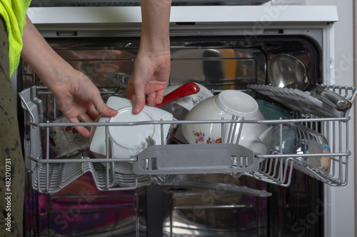 Get clean washed dishes from the dishwasher