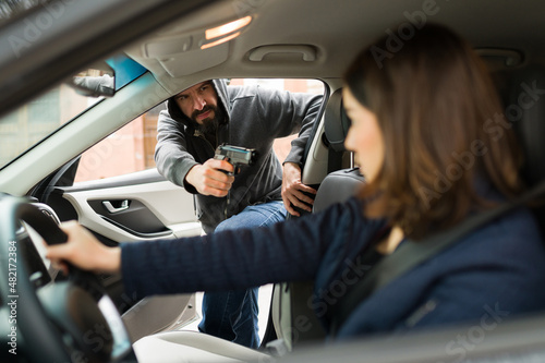 Angry thief stealing a car from a victim photo