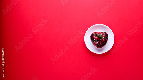 Cake in the form of a heart on a red background. Valentine's Day.