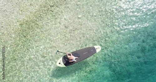 Little boy on a paddleboard.
Cute child learning on a paddleboard. Aerial view.