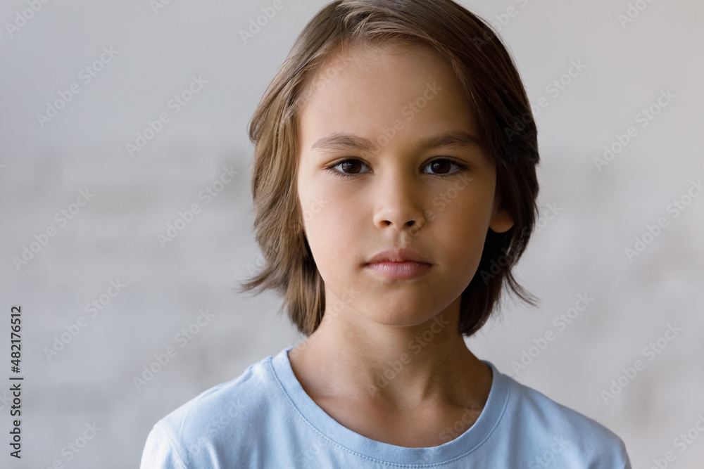 Serious pretty boy head shot portrait. Male school kid, schoolchild