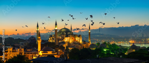 Fotografia Flock of birds over mosque