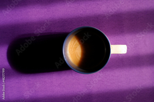 close up of a cup of latte on a purple background