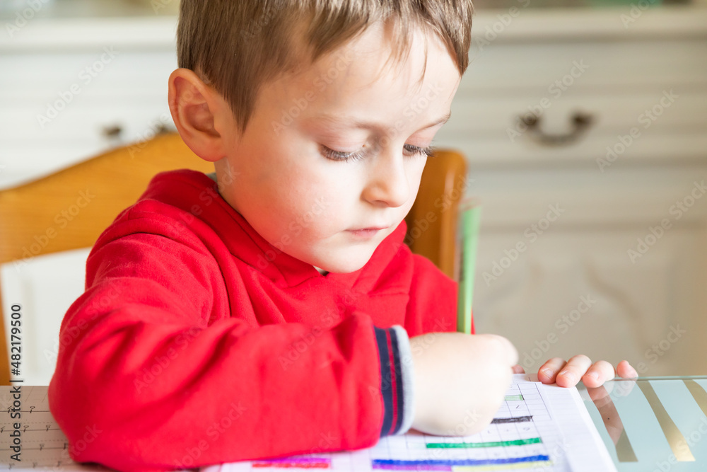 6 years old boy learning at home. Elemantary age caucasian child. 6 years old boy learning at home. Elemantary age caucasian child.