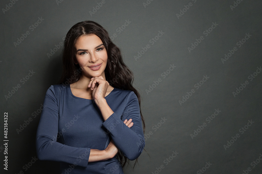 Happy beautiful woman smiling and standing with crossed arms on gray background. Happy beautiful woman smiling and standing with crossed arms on gray background.