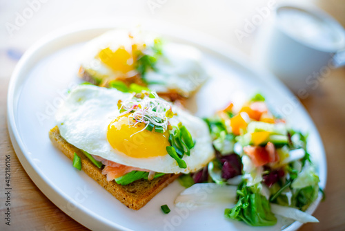 Breakfast with fried eggs on toasts on a restaurant table