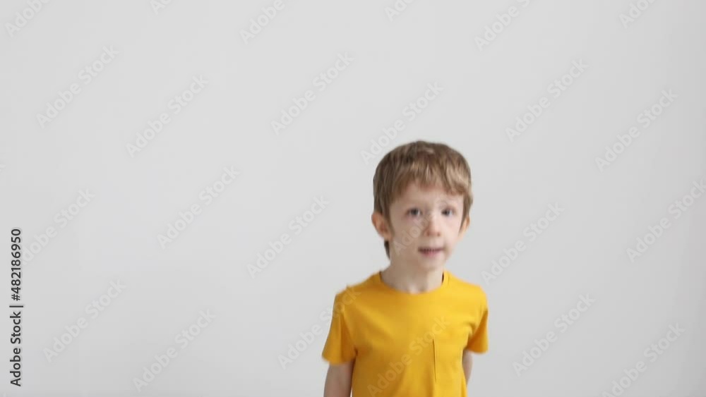 Happy fun kid in yellow t-shirt jumping on sofa at home Happy fun kid in yellow t-shirt jumping on sofa at home