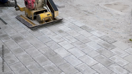 Machine for compaction, vibrating plates on paving stones. The concept of laying paving slabs and paving stones photo