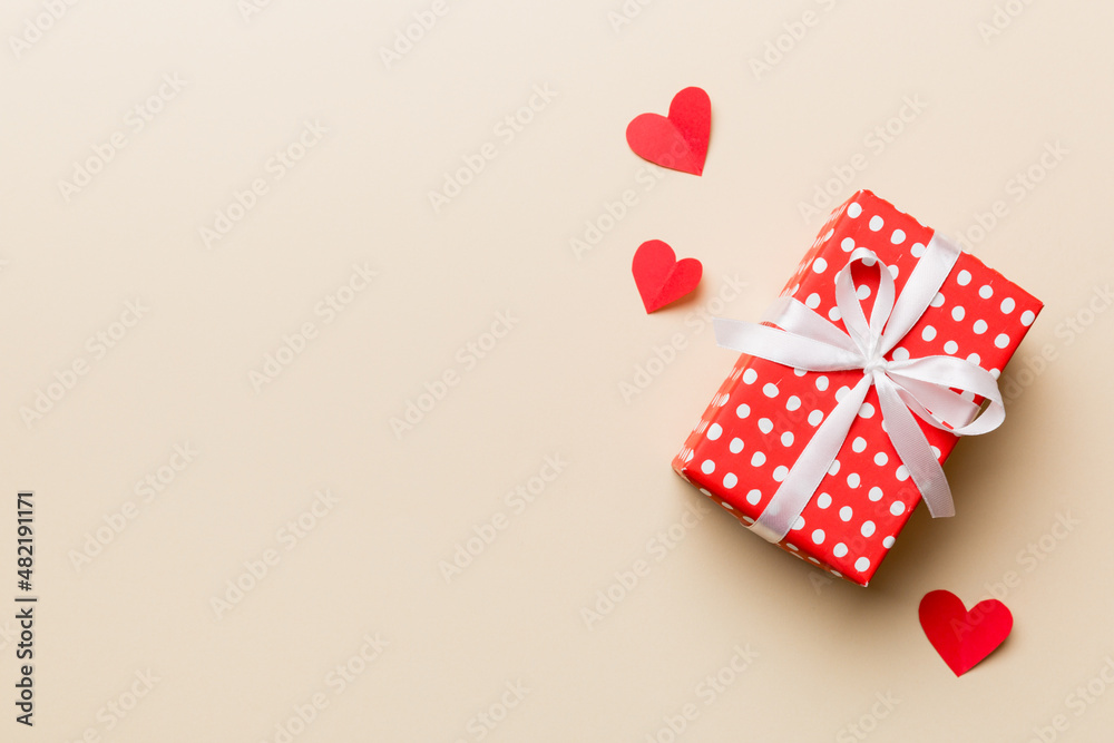 Valentine day composition: red gift box with bow and heart. Christmas present. View from above. Space for text. Holday greeting card Valentine day composition: red gift box with bow and heart. Christmas present. View from above. Space for text. Holday greeting card